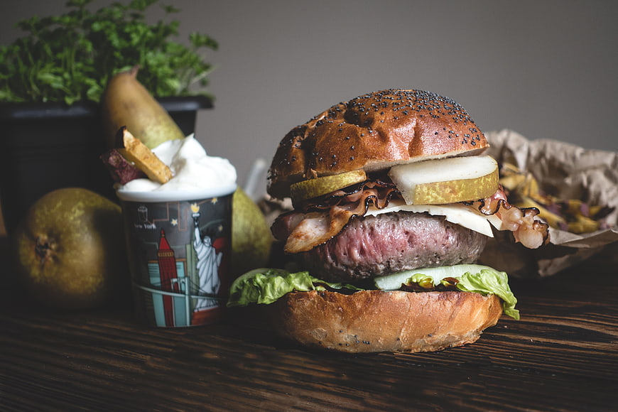 Gourmet burger with pear, bacon, and ice cream on wood