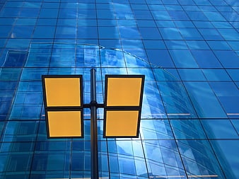 Modern street lamp with yellow lights against blue glass building