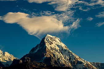 Majestic Snow-Capped Mountain Peak with Dramatic Cloud