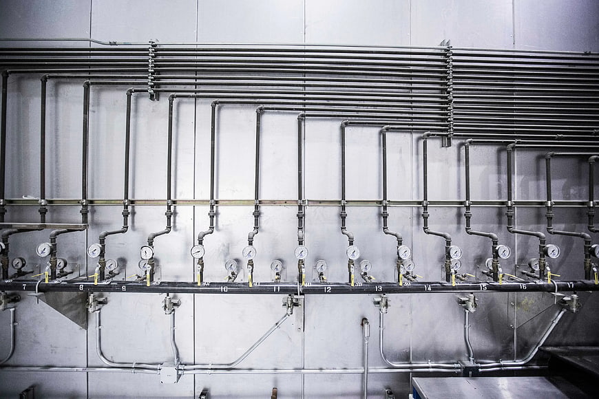 Industrial steel pipes and pressure gauges on wall