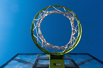 Low angle view of green basketball hoop against blue sky