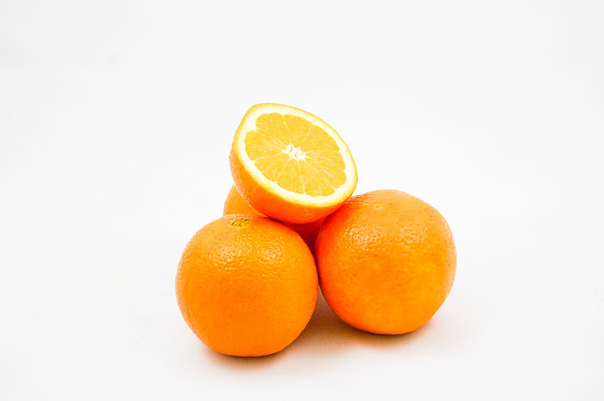 Fresh Oranges on White Background with One Cut in Half