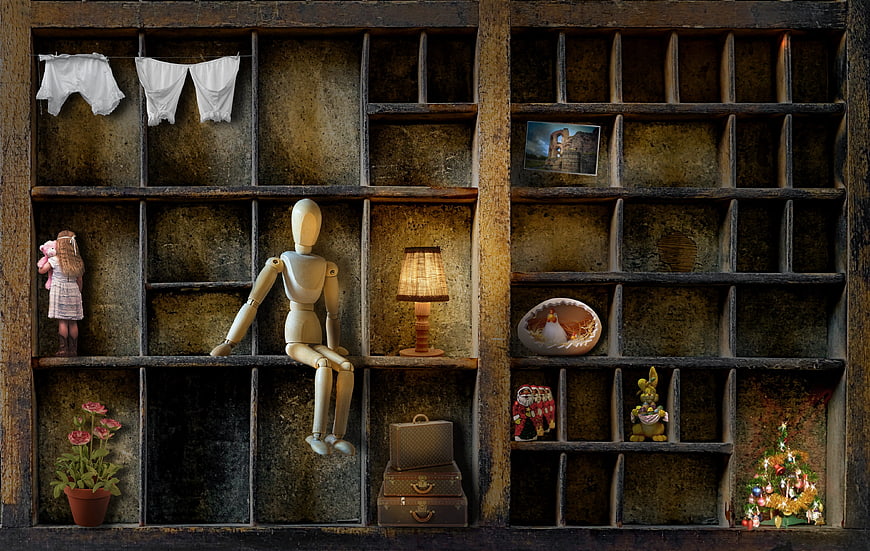 Melancholic wooden mannequin sitting in a rustic grid shelf with vintage objects