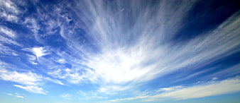 Dramatic Sunburst Through Wispy Cirrus Clouds in Blue Sky