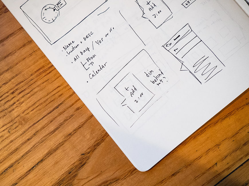 Hand-drawn UI wireframes and notes on notebook