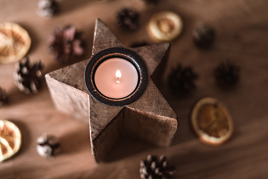 Rustic wooden star candle holder with tea light and pinecones