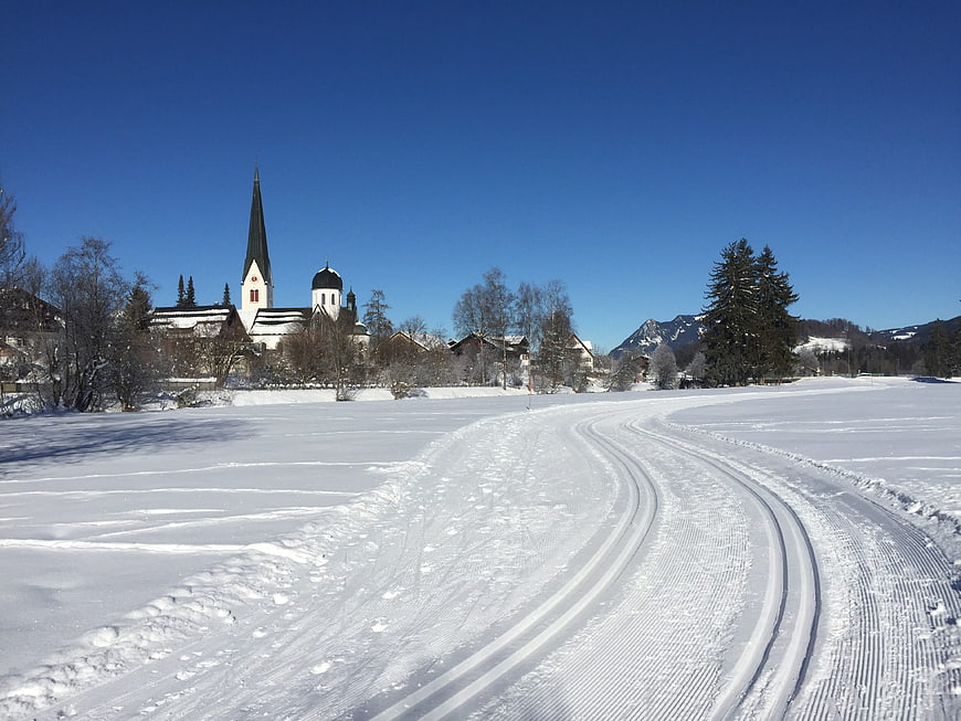 Cross-country ski tracks in snowy winter landscape with church