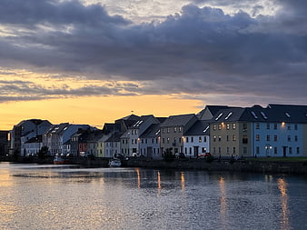 Colorful European Waterfront Town At Dusk With Dramatic Clouds
