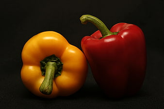 Red and Yellow Bell Peppers on Black Background