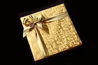 Gold Swirl Pattern Gift Box With Satin Ribbon On Black Background