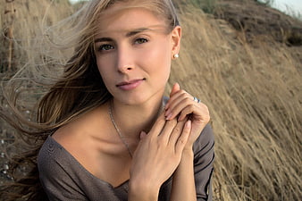 Portrait of beautiful blonde woman with windblown hair in field