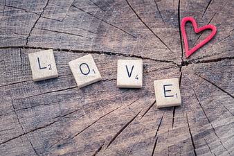 Scrabble Tiles Spelling Love on Rustic Wood with Red Heart