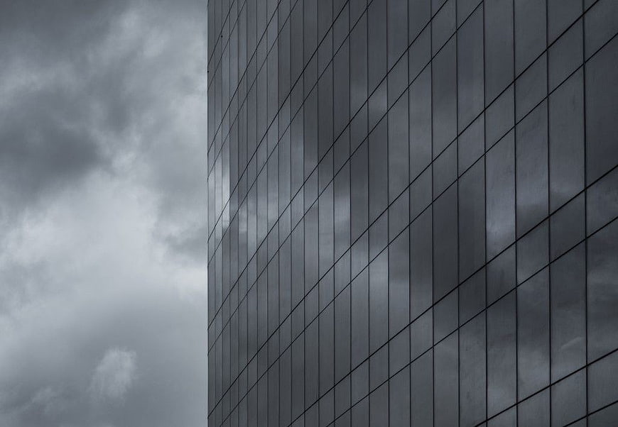 Modern Glass Skyscraper Reflecting Stormy Clouds