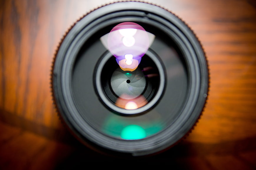 Close-up of camera lens with colorful bokeh reflections