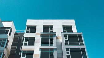 Modern White Apartment Building Against Blue Sky