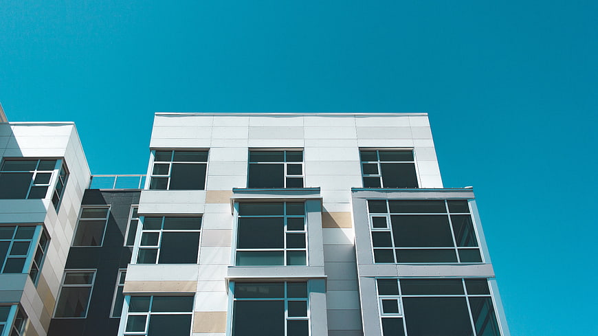 Modern White Apartment Building Against Blue Sky