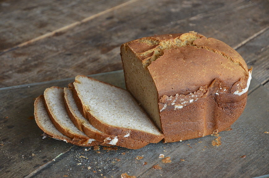 Sliced homemade brown bread on a rustic wooden table