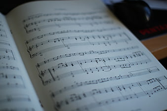 Close-up of open sheet music book with blurred background