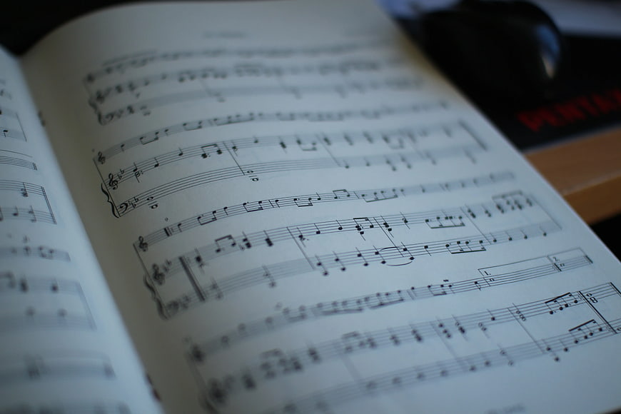 Close-up of open sheet music book with blurred background