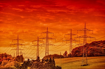 Dramatic Orange Sky Over Power Lines and Rolling Hills