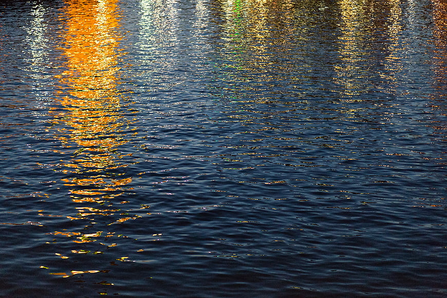 Golden Reflections on Rippling Dark Water Surface