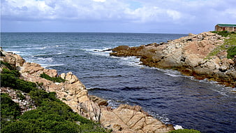 Rugged Rocky Coastline with Ocean Waves and Coastal House