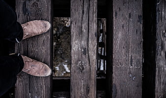 Brown leather boots on weathered wooden planks