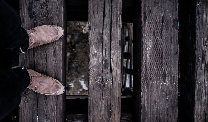 Brown leather boots on weathered wooden planks