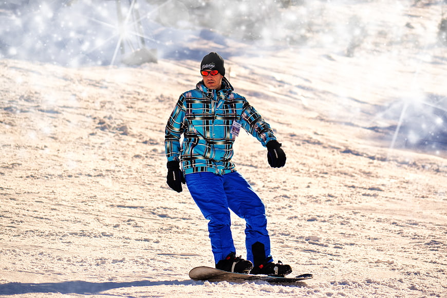 Snowboarder in Blue Plaid Jacket on Snowy Slope