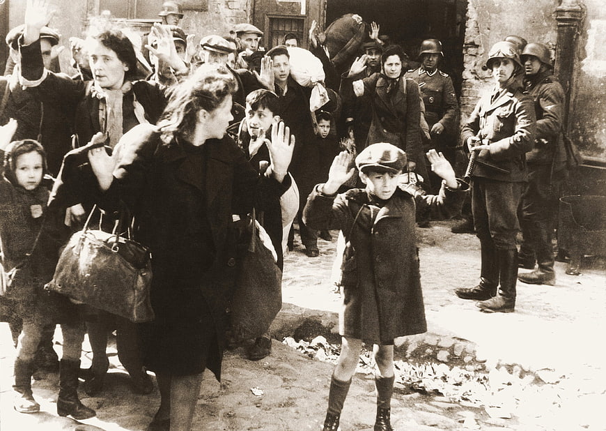Historical Black and White Photo of Warsaw Ghetto Residents with Hands Raised