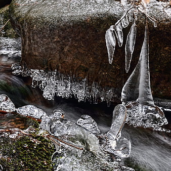 Frozen waterfall with icicles on mossy rocks
