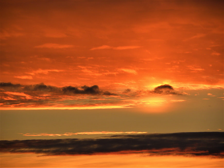 Vibrant Orange Sunset Sky with Dark Clouds
