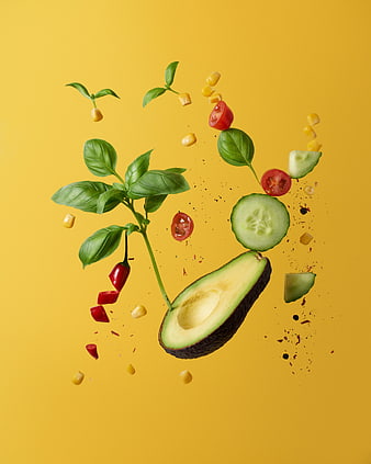 Fresh avocado, basil, and vegetables floating on yellow background