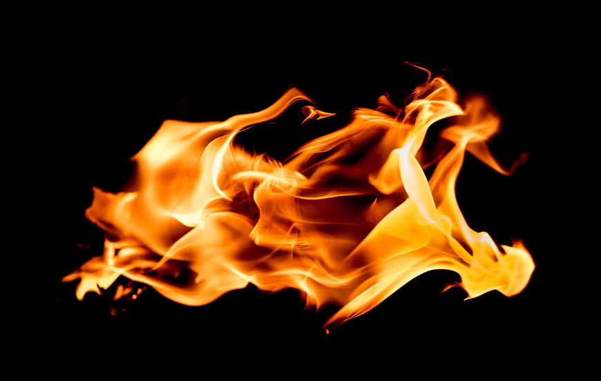 Dynamic orange and yellow flames isolated on black background