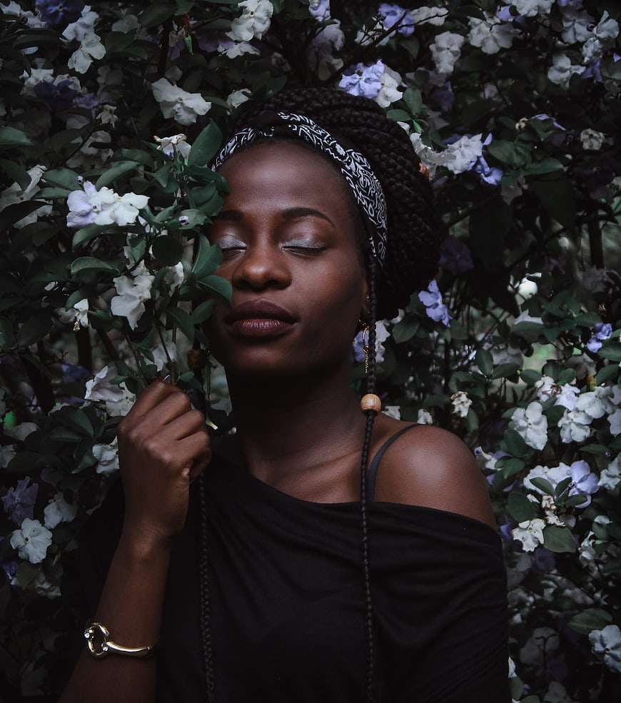 Serene Black Woman Smelling White and Purple Gardenia Flowers