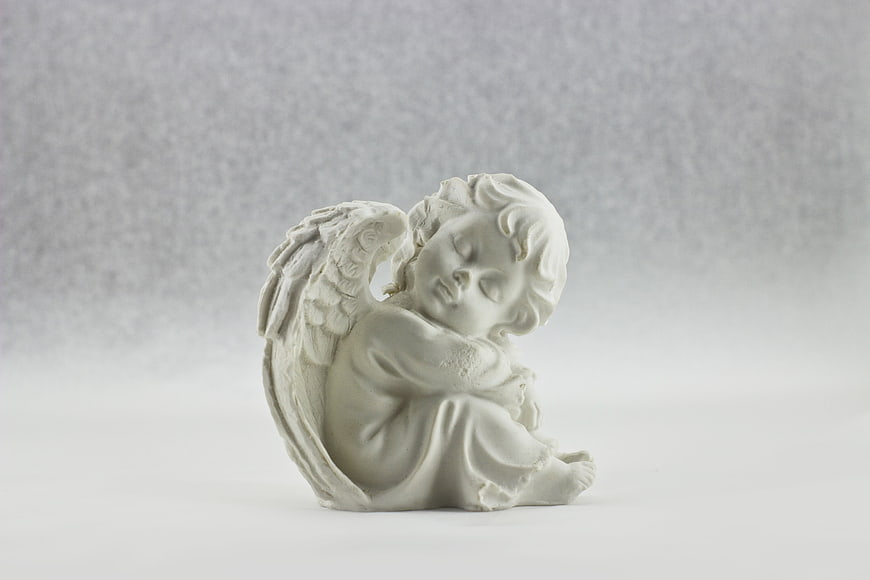 White Sleeping Angel Statue on Gray Background