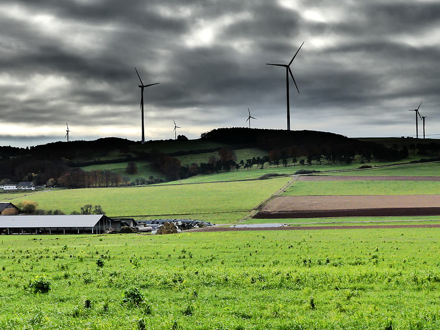 Wind turbines on rolling green hills under dramatic cloudy sky
