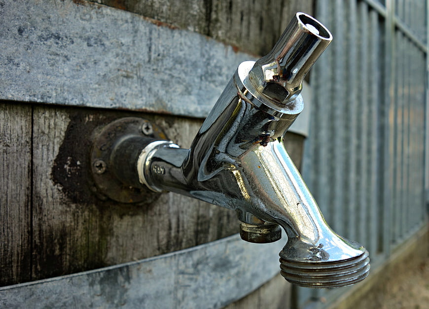 Close-up of shiny chrome tap on wooden barrel