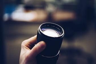 Hand holding vintage camera lens close-up