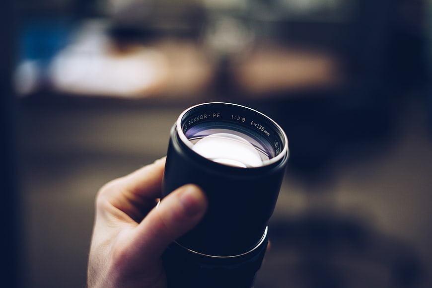 Hand holding vintage camera lens close-up