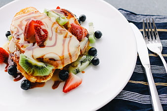 French Toast with Fresh Berries and Kiwi on White Plate