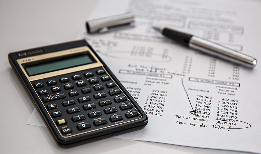 Black Calculator and Pen on Financial Investment Documents