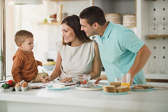 Happy family preparing breakfast together in modern kitchen