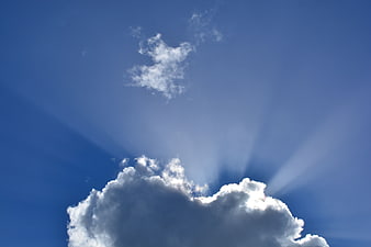 Dramatic Blue Sky with Sun Rays and White Clouds