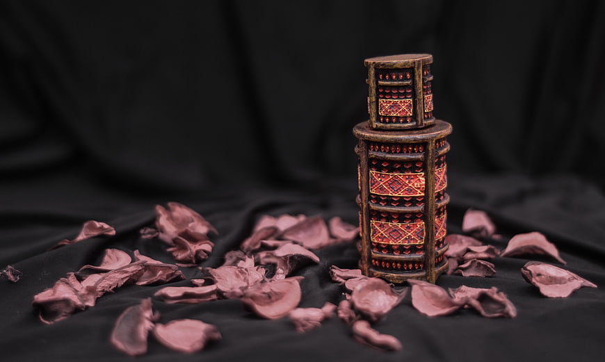 Ornate Decorative Box with Dried Rose Petals on Black Fabric
