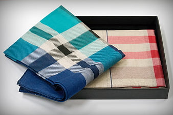 Two folded plaid handkerchiefs in a black presentation box