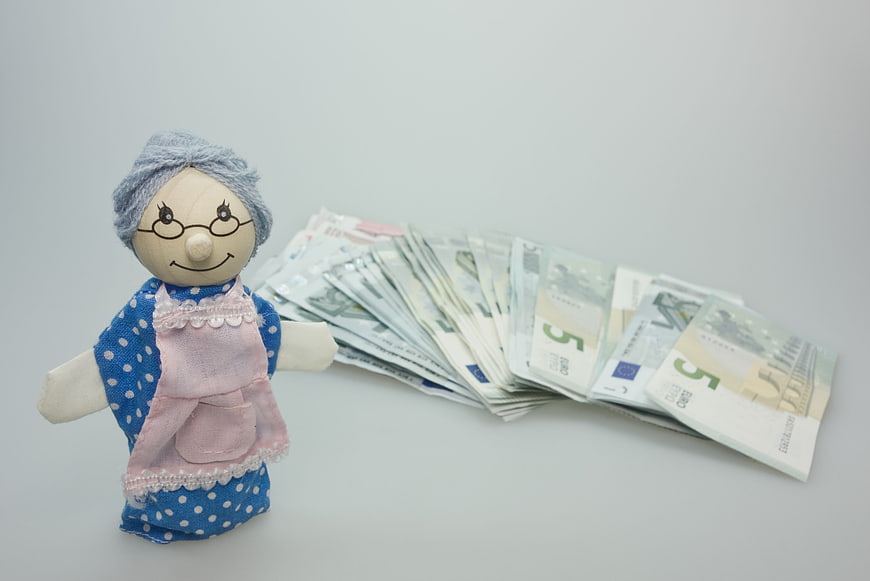 Wooden Granny Puppet With Euro Banknotes On White Background