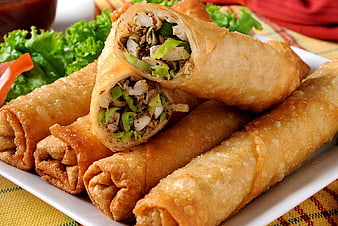 Crispy fried spring rolls with vegetable filling on white plate