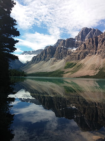 Serene mountain lake with perfect reflection and pine trees