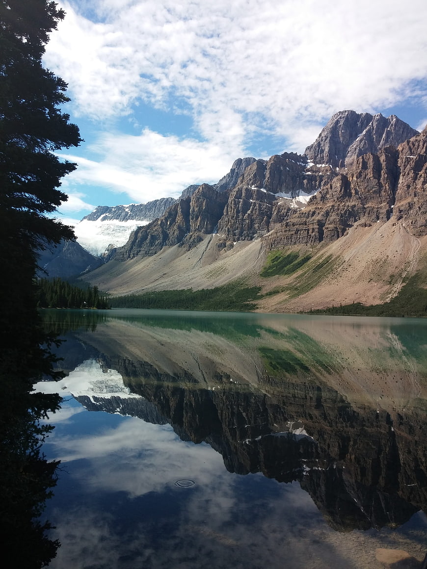 Serene mountain lake with perfect reflection and pine trees